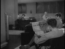Wider shot of Jimmy in the newsroom